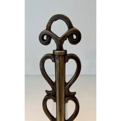 Pair of Brass and Iron Andirons with Stacked Scroll-Column Uprights on Arched Bases, in the Style of Raymond Subes