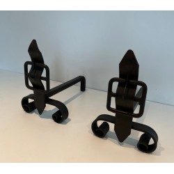 Pair of Wrought Iron Andirons with Flame Finials and Strap-Buckle Midsection. France. Circa 1950.